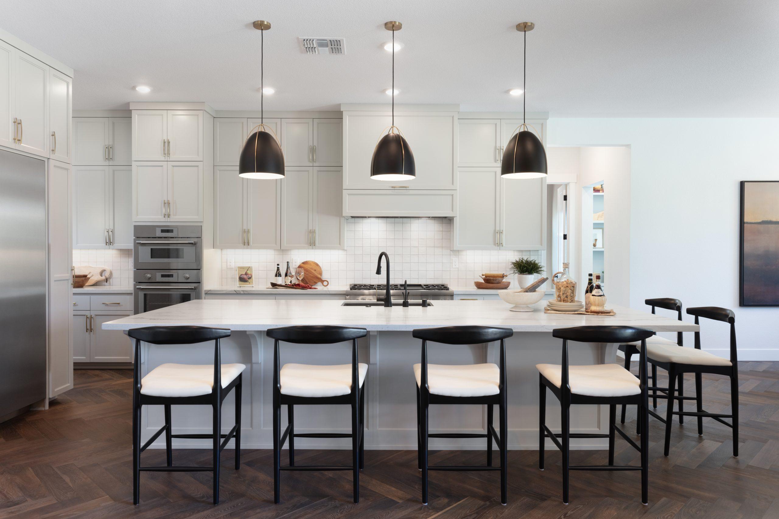 Modern white kitchen with large island and pendant lights